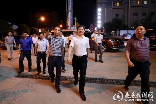 （李荐国在市体育中心附近的檀香路下车，一边步行一边察看路边的夜宵门店和群众体育文化活动情况）