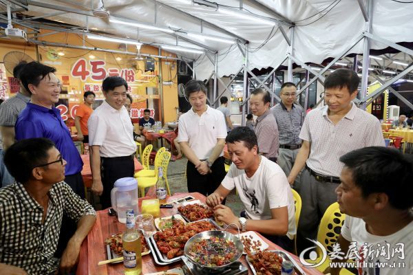 （在涟水河风光带北岸是娄底著名的夜市一条街，李荐国一行走进一家夜宵店，与吃宵夜的顾客热情攀谈）
