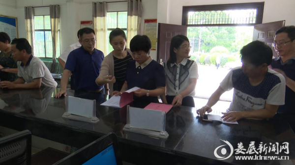 （陈慈英在甘棠镇民生服务大厅查看相关资料）