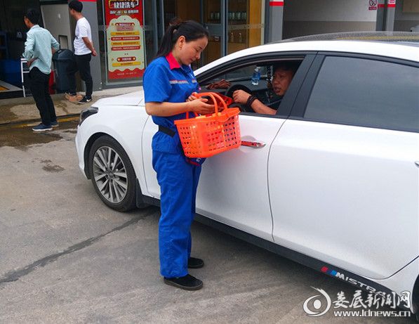 （加油员向车主发放消防宣传资料）