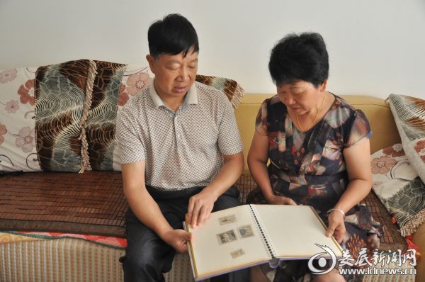 父母在家中翻阅儿时的照片