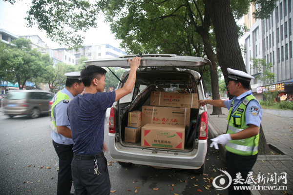 （执勤交警现场查获一辆客车违规载货行为）