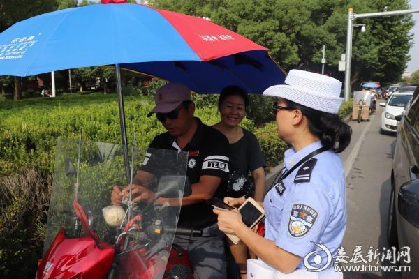 （交警对非法改装摩托车主进行批评教育并没收伞具）