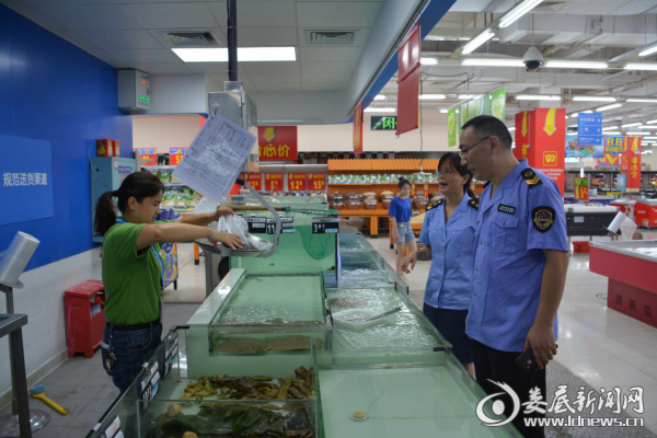 图为执法人员在对超市水产品进行采样。