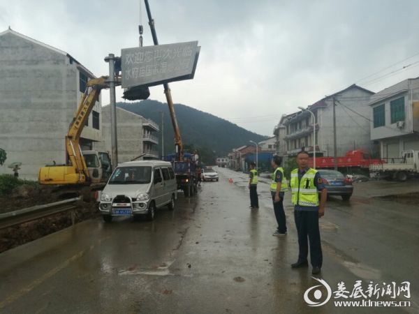 （路政执法人员正在协助拆除指路牌）