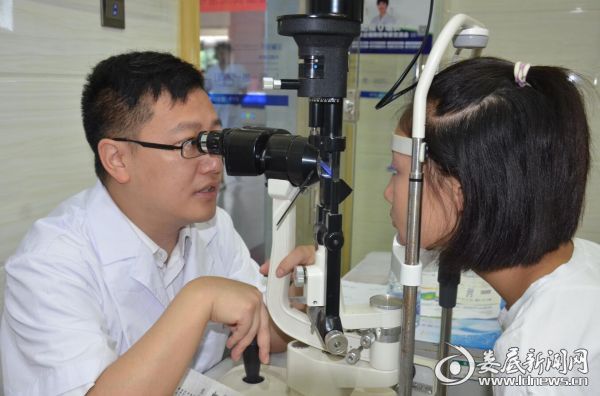 近视防控专家陈兆为现场参会孩子检查眼睛