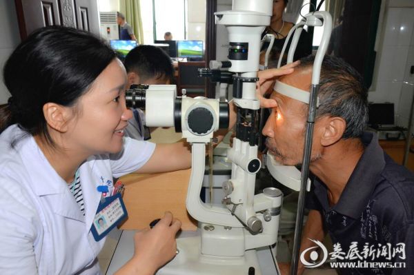 娄底爱尔眼科医院眼底病中心主任唐玖鸿为贺安帮老人做术后复查