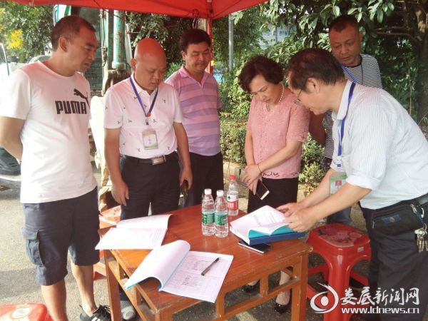 省督查组一行在查看应急值班日志和生猪进出口检疫消毒台账