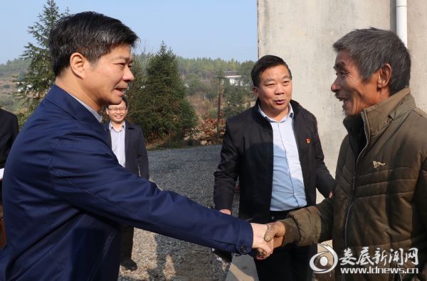 李荐国随机走访了脱贫户龙祥和，并和他亲切握手交谈