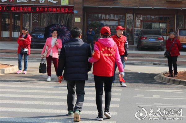 （党员志愿者护送行人过马路）