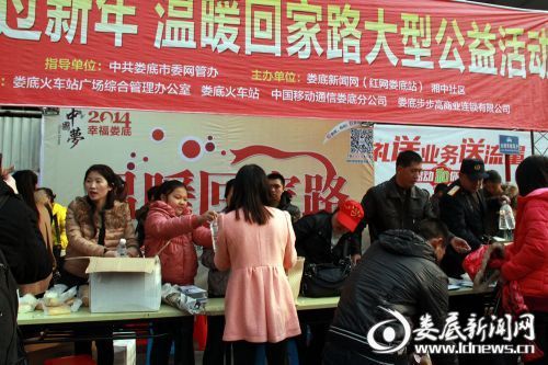 2014,温暖回家路活动现场,志愿者将爱心食物发放给返乡人员