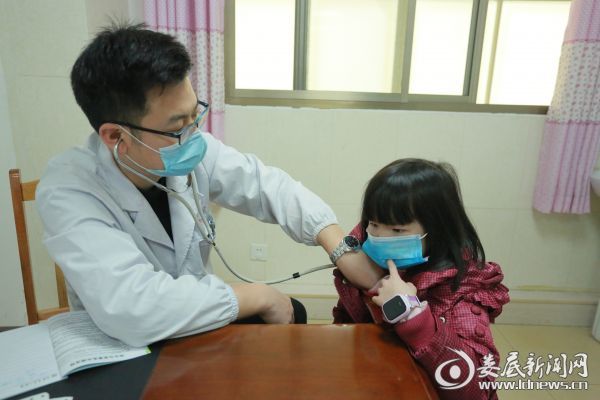 （儿科副主任医师颜新良为患儿听诊）