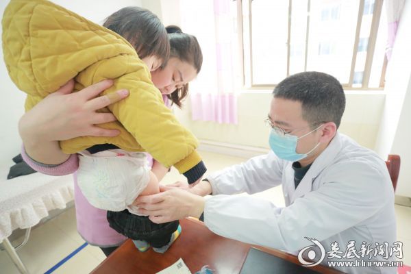 （儿科主治医师邓向华为患儿检查身体）