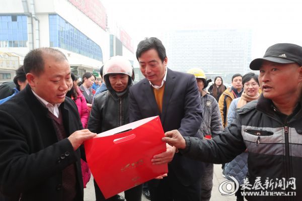 (吴建平查看“温暖回家路”爱心春运礼包)