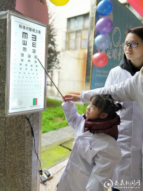 医务人员教孩子们检测视力