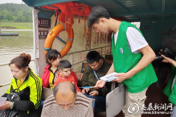 志愿者梅山龙宫登船口给过往的游客分发宣传手册