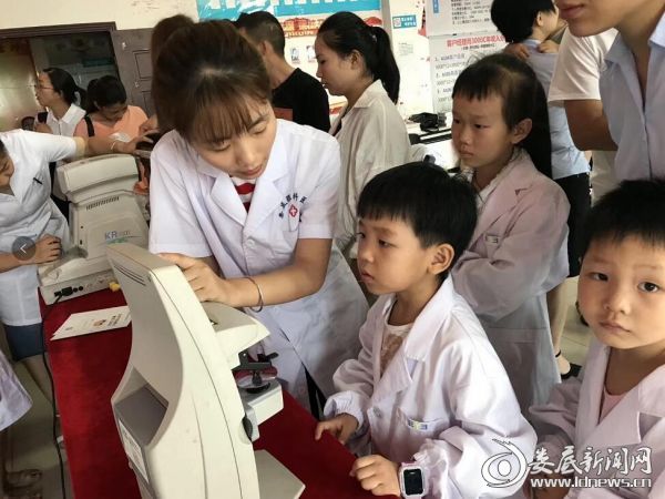 娄底爱尔眼科医护人员给“小医生”讲述仪器使用方法