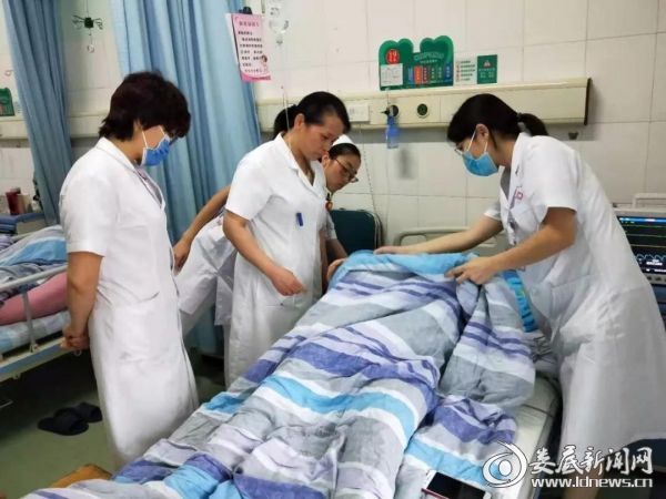 （术后，朱晓霞查看产妇的伤口愈合情况）