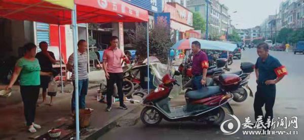 （行动小组对违规摆放车辆人员进行教育谈话）