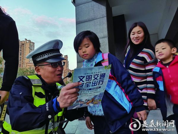 交警在街头为一小学生讲解安全知识，路过群众驻足观望