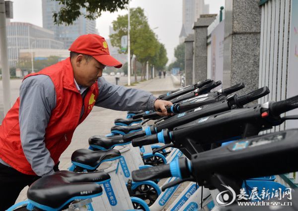 娄底街头志愿者在摆放共享单车一
