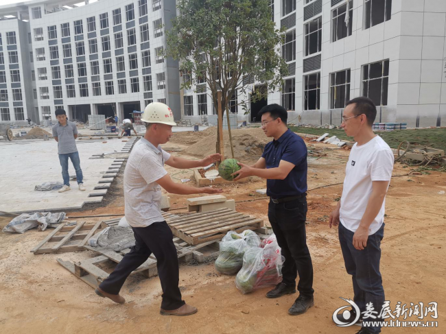 （图为慰问组一行为项目工地一线职工送去防暑物资）