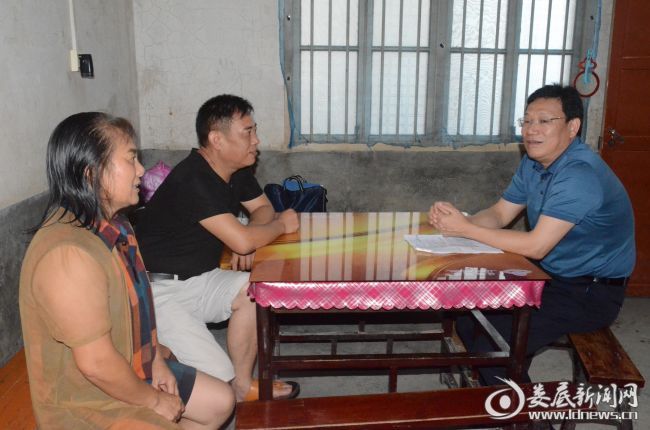 （华学健在贫困户谭周连家中走访）