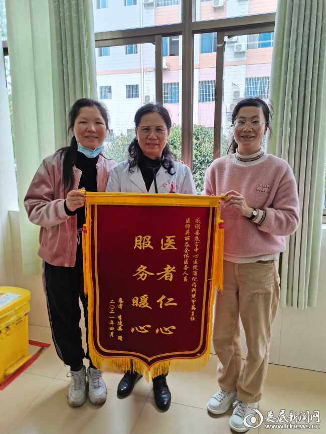 李阿姨的家属将锦旗送到熊甲英主任（中）手上