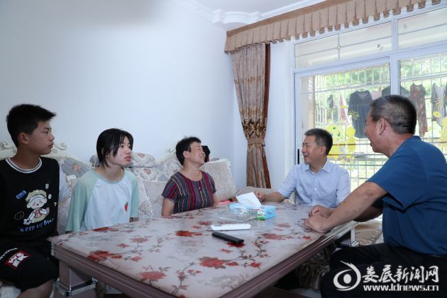 （在安平镇易地扶贫搬迁集中安置点与邱国华一家拉家常）