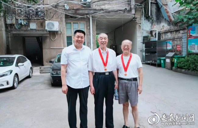 （中心党委书记、主任邱胜平与获得纪念章的老党员合影）
