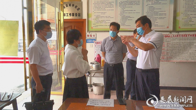 （吴建平向社区工作人员了解防控措施落实情况）