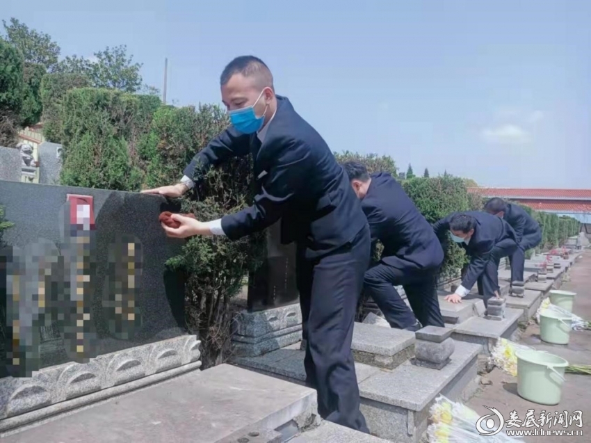 （工作人员擦拭墓碑）