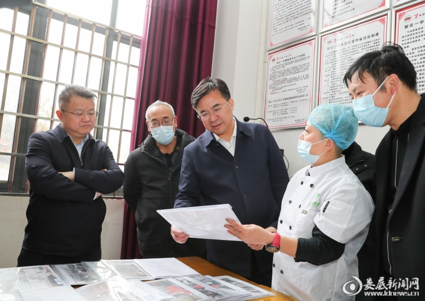 △在新化一中食堂，邹文辉详细了解了原料采购、食品贮存、生产加工、员工管理、学生就餐等各环节流程，翻阅相关台账资料