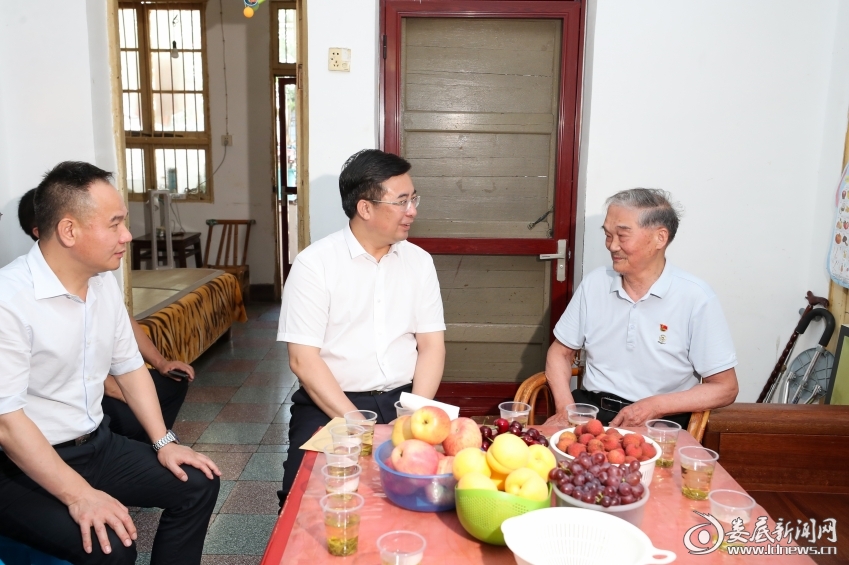 △邹文辉来到老党员曾南勋家中，与他促膝交流，听老人追忆烽火岁月中的革命故事。