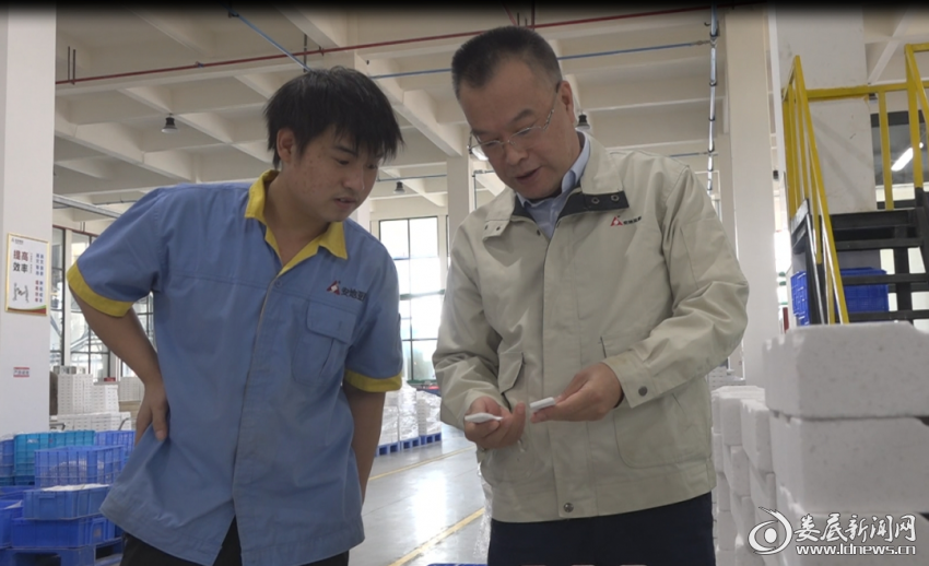 (康丁华在车间查验产品质量)