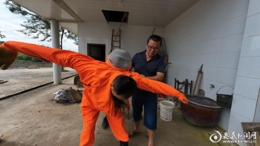 （图为消防员在穿防蜂服，为销除土蜂窝做准备。）