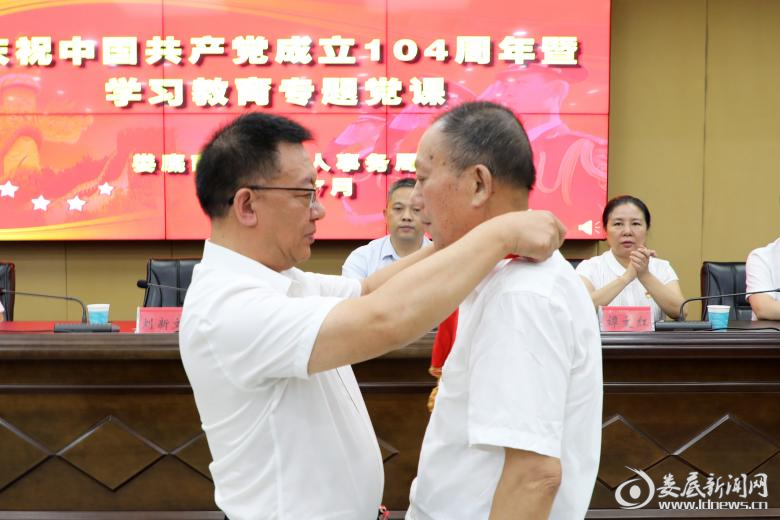 （局党组书记、局长刘新文为“光荣在党50年”老党员颁发纪念章）
