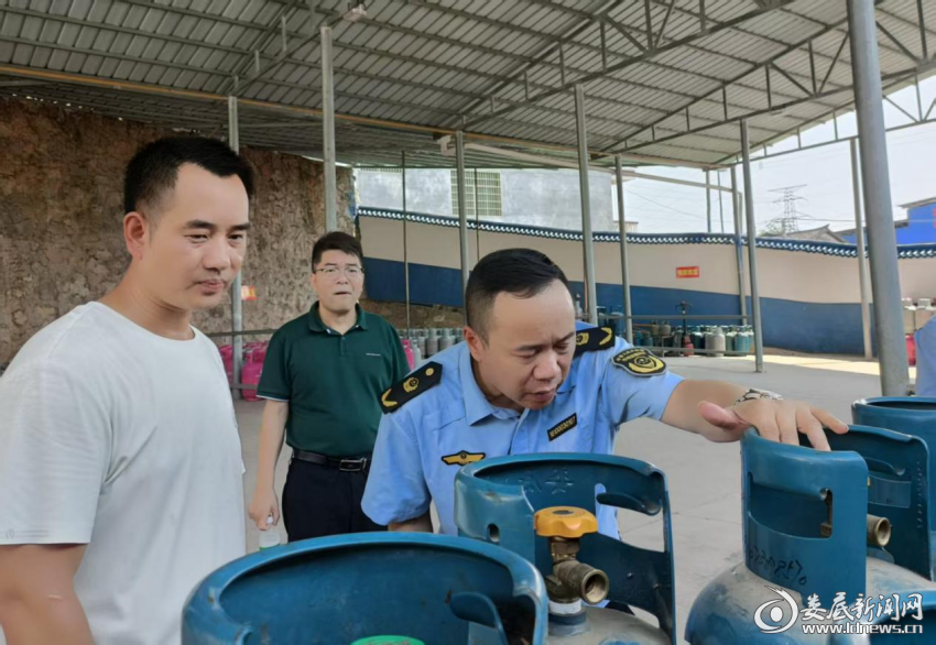 （图为检查组抽查液化气瓶安全）