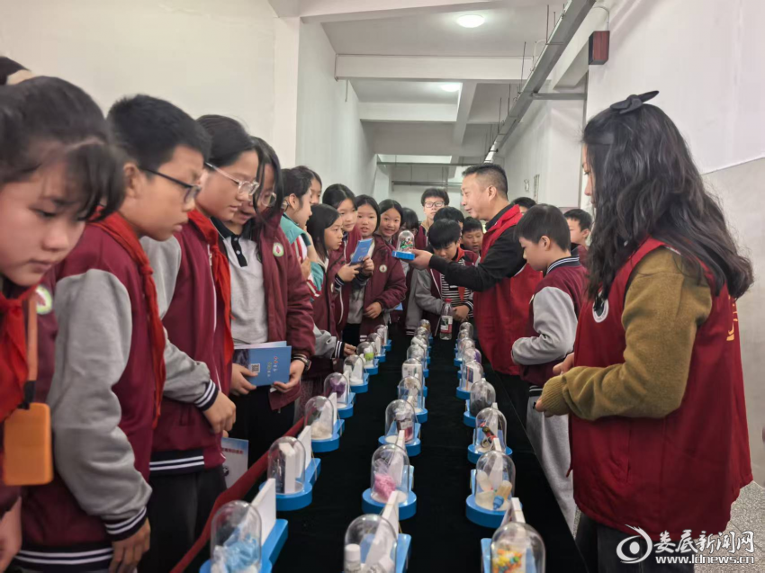 上梅街道北塔学校师生们在大厅观看毒品仿真模型。