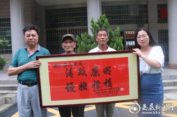 伍余光(右二)等烈属为民政局领导赠送牌匾