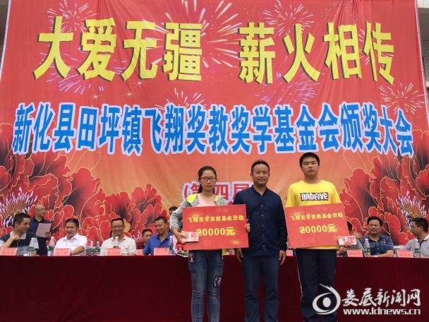 (康飞翔现场给两位优秀贫困学生颁发两万元教育资助)