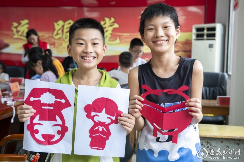 7月27日，孩子们展示自己的剪纸作品。