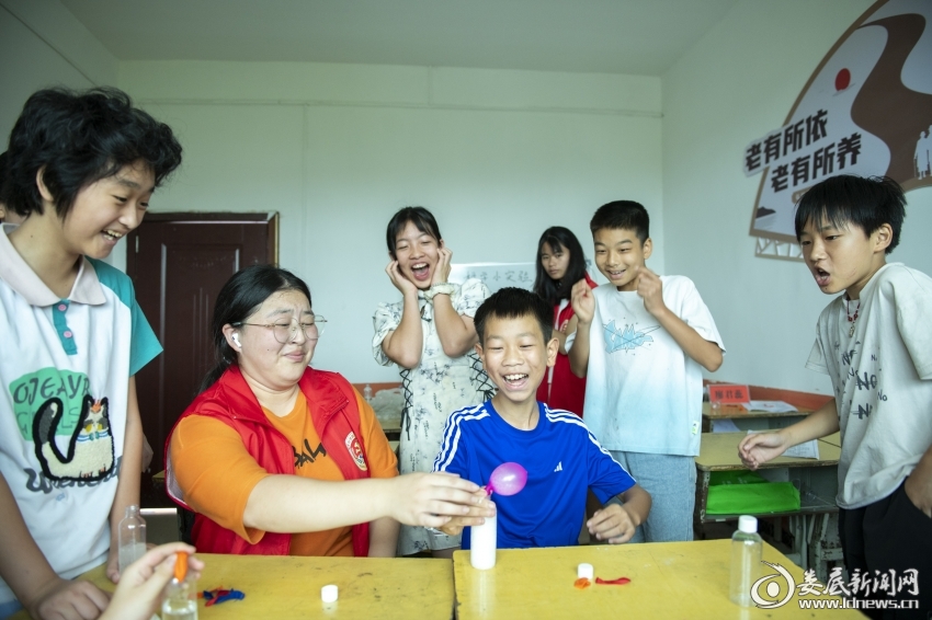 7月27日，大学生志愿者和孩子们体验科学小实验。