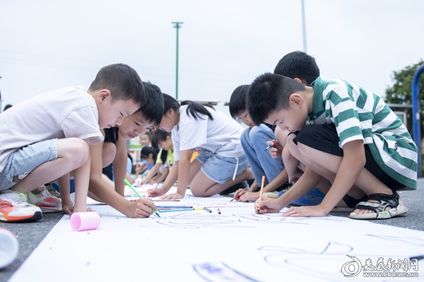 7月27日，孩子们在百米长卷上绘画。