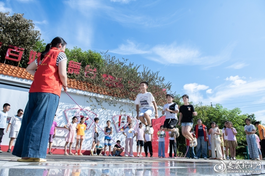7月26日，大学生志愿者和孩子们一起跳绳。
